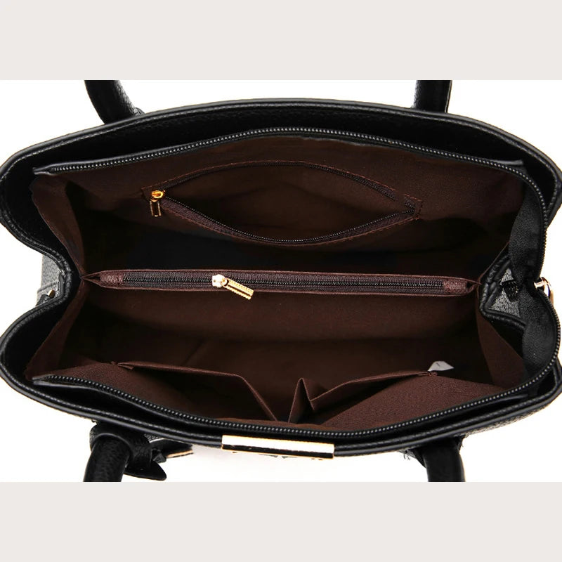 Black handbag with gold zipper on a white background