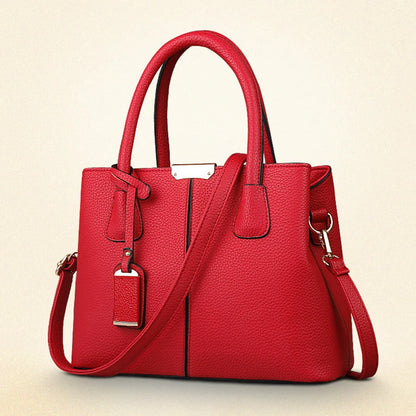 Red handbag with a shoulder strap on a beige background