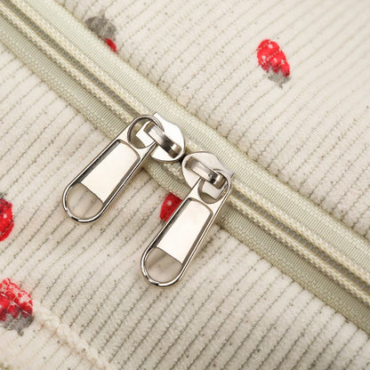 Close-up of a zipper on a textured fabric background with red and gray floral patterns.