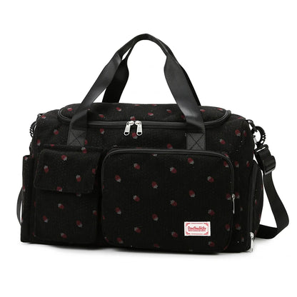 Black polka dot diaper bag with a visible brand label on a white background