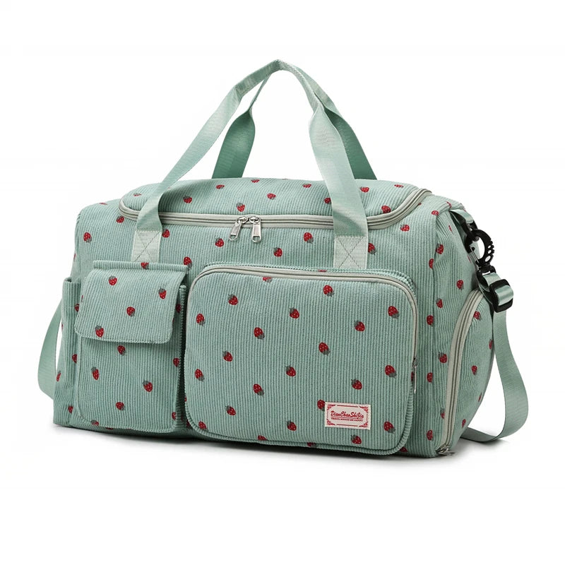 Green duffel bag with red polka dot pattern on a white background