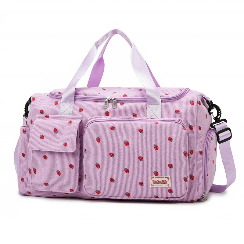 Pink diaper bag with red polka dots on a white background