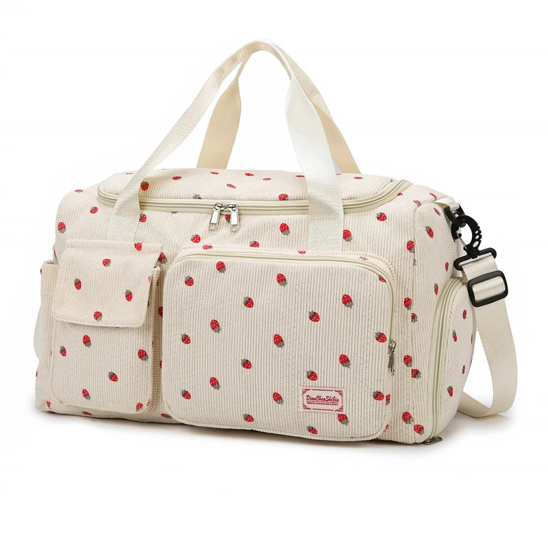 Beige diaper bag with red polka dot pattern on a white background