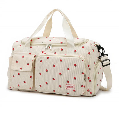 Beige diaper bag with red polka dot pattern on a white background