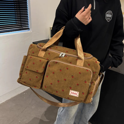 Person holding a brown polka dot bag with a visible brand label.