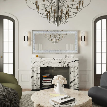 Living room with marble fireplace, chandelier, and decorative mirror.