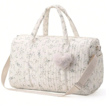 Floral-patterned duffel bag with a pom-pom on a white background