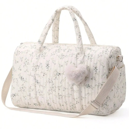 Floral-patterned duffel bag with a pom-pom on a white background