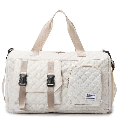 Beige duffel bag with quilted design and black zippers on a white background