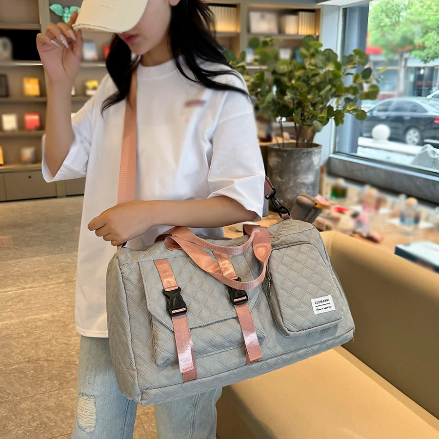Person holding a gray bag with pink straps in an indoor setting