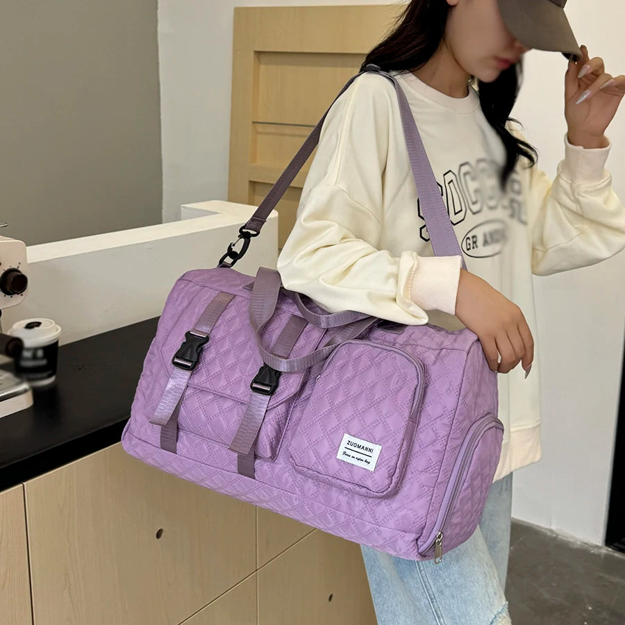 Person holding a purple duffel bag in an indoor setting