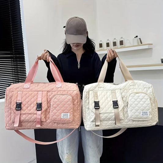 Person holding two quilted duffel bags, one pink and one beige, in a room with a shelf in the background.