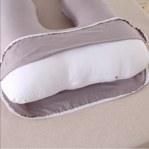 U-shaped pillow with gray exterior and white interior on a beige surface