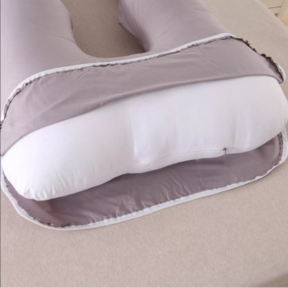 U-shaped pillow with gray exterior and white interior on a beige surface