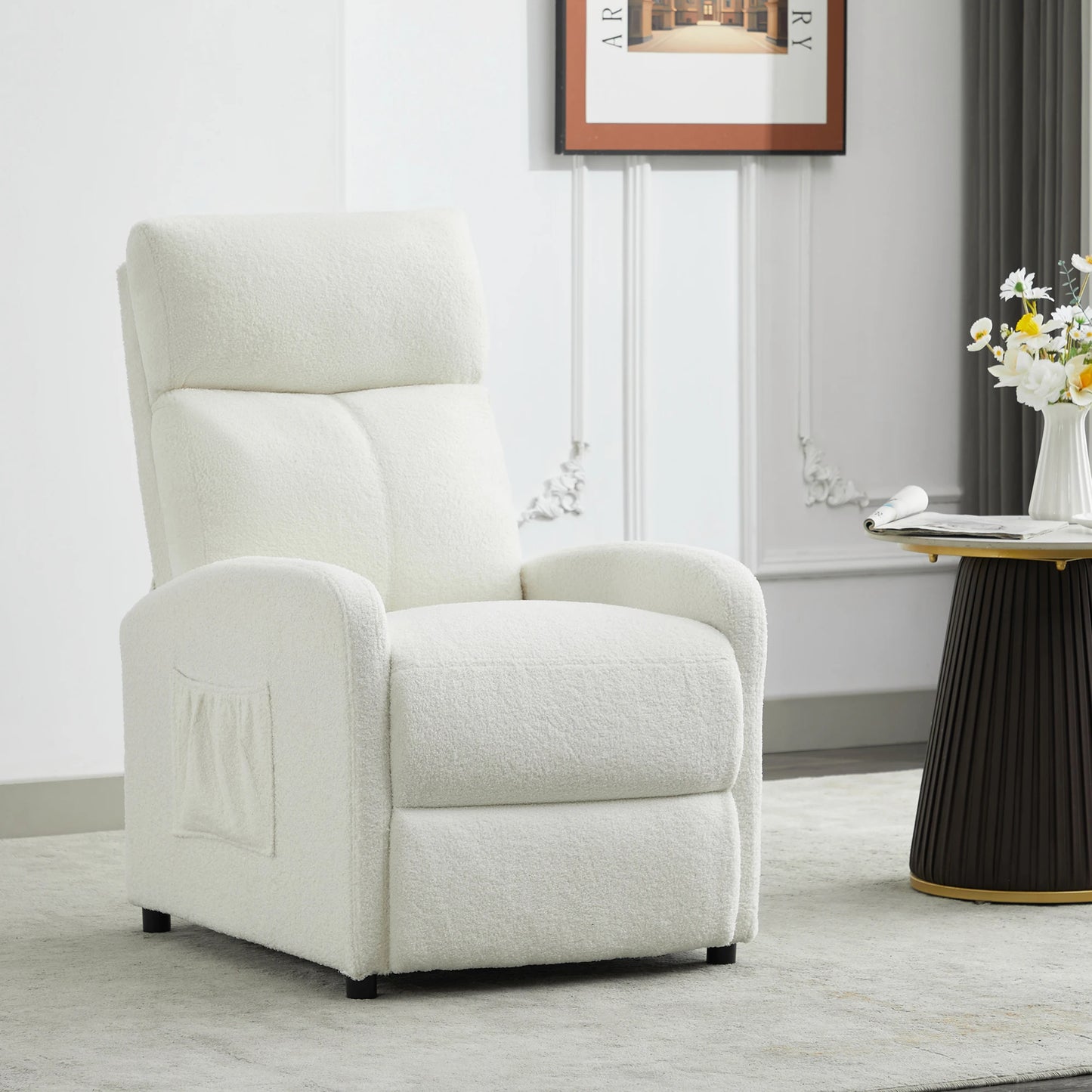 White recliner chair in a living room setting with a table and flowers.