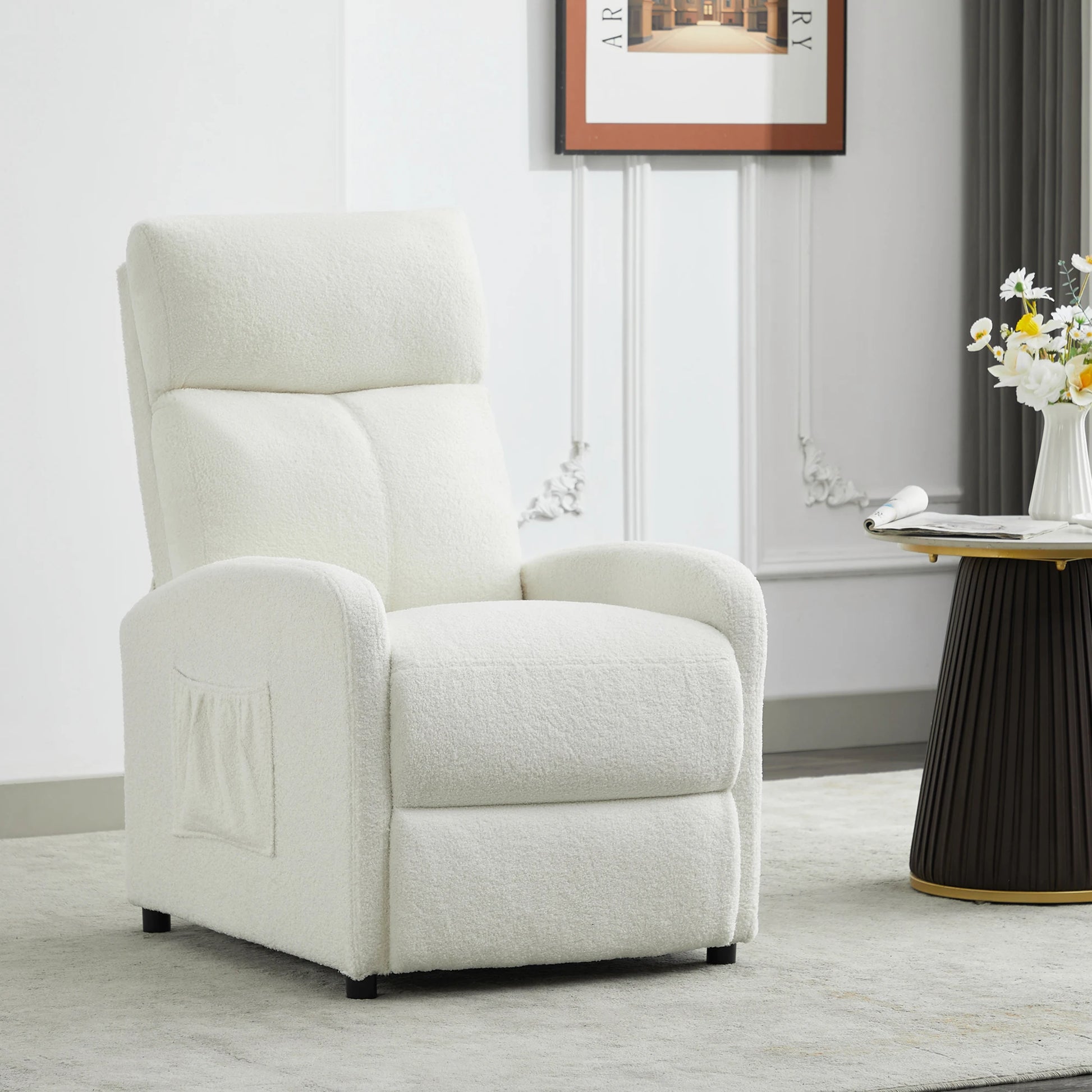 White recliner chair in a living room setting with a table and flowers.