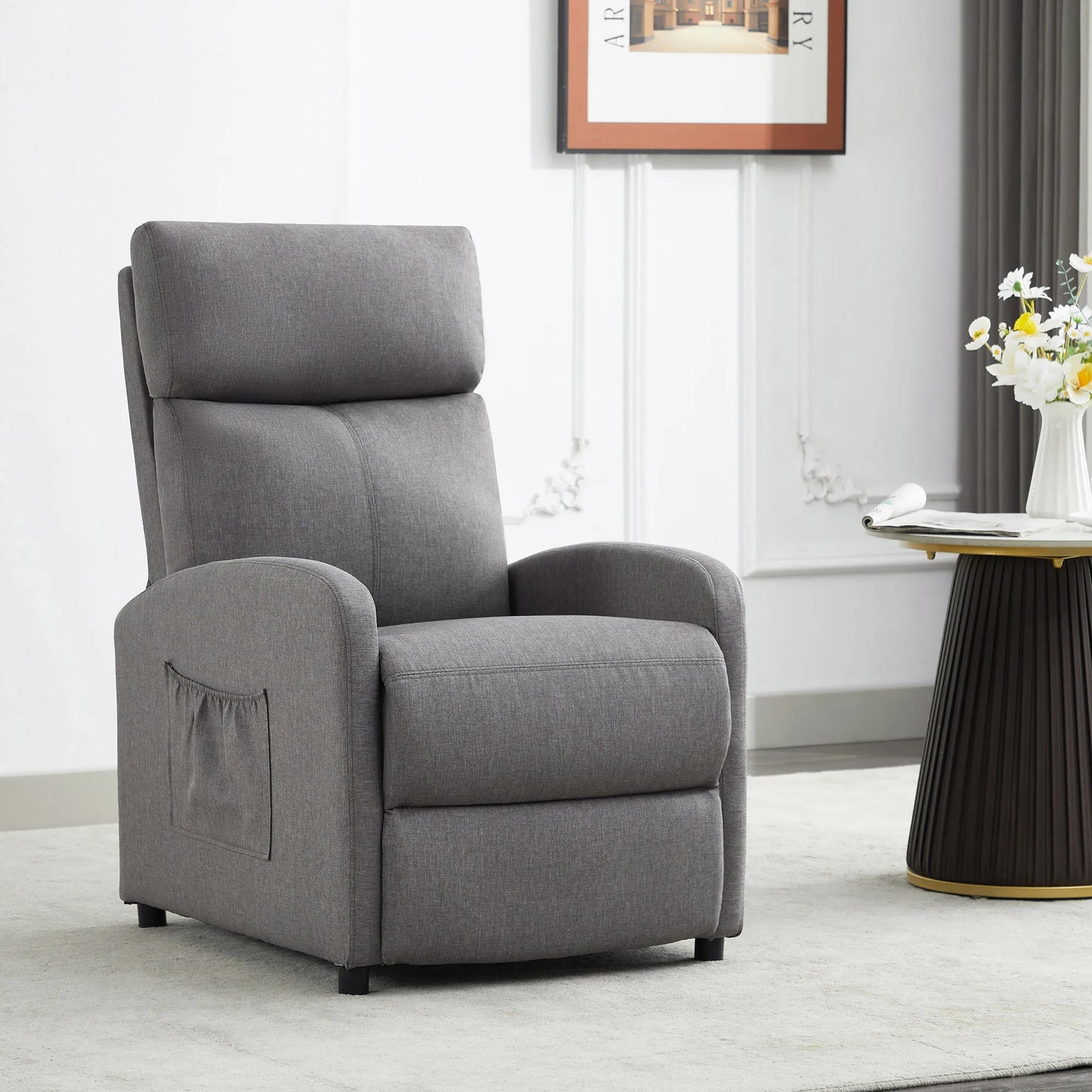 Gray recliner chair in a living room setting with a table and flowers.