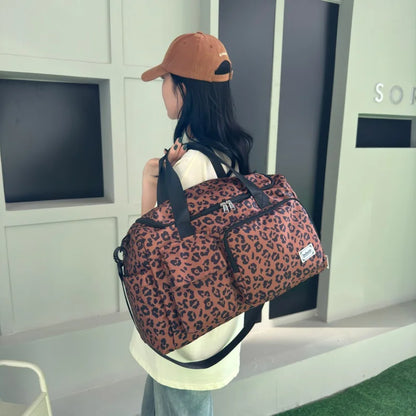 Person carrying a leopard print duffel bag in an indoor setting