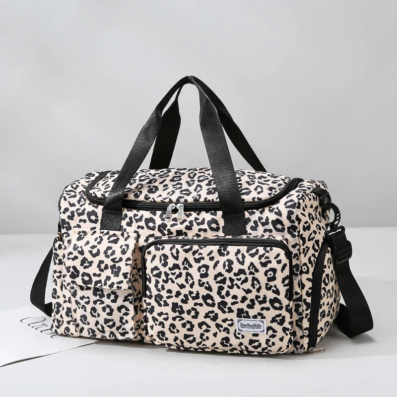 Leopard print duffel bag with black straps on a light gray background