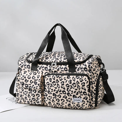 Leopard print duffel bag with black straps on a light gray background