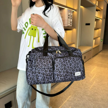 Person holding a leopard print duffel bag in an indoor setting