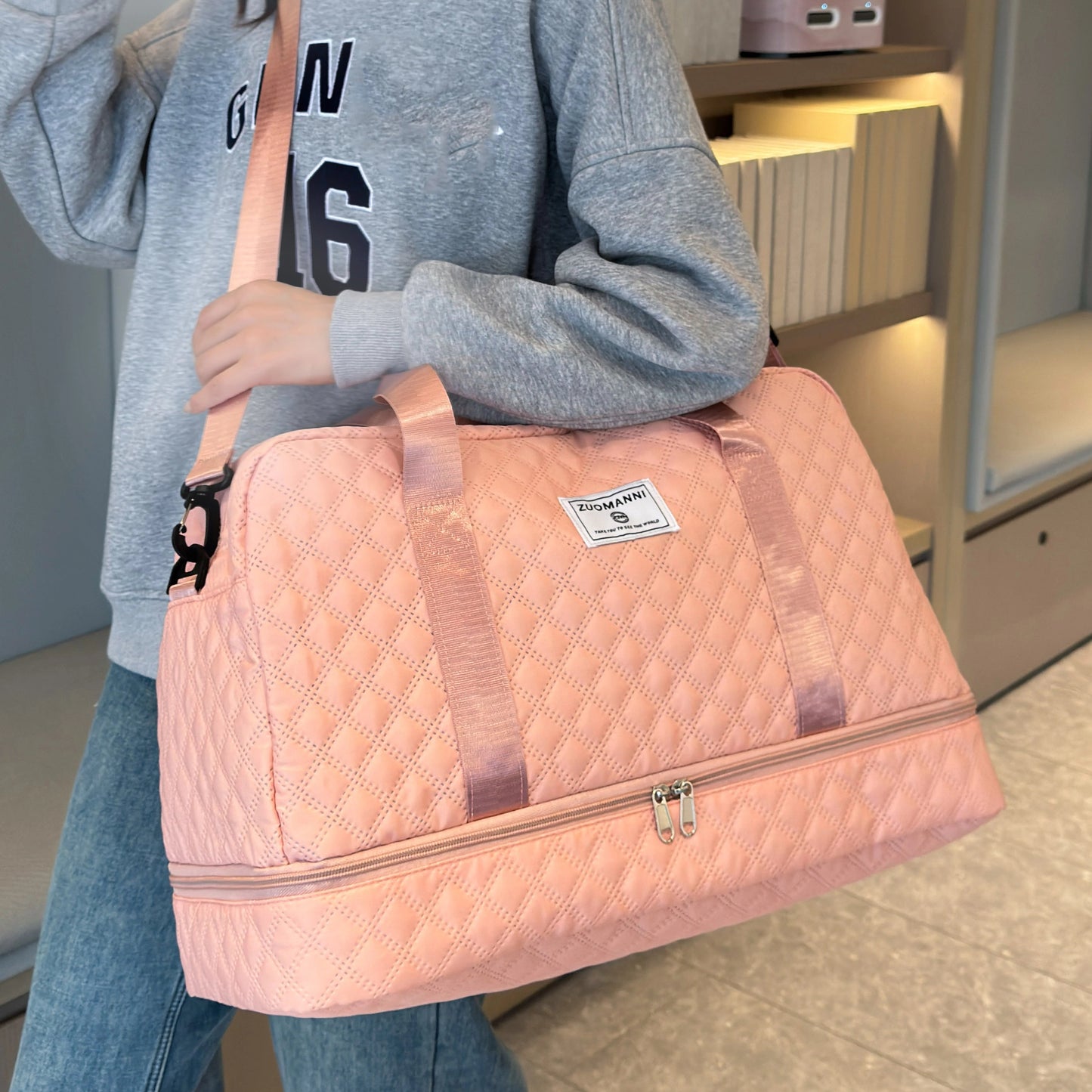 Person holding a pink quilted bag in an indoor setting