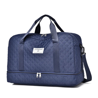 Blue quilted duffel bag with a visible brand label on a white background