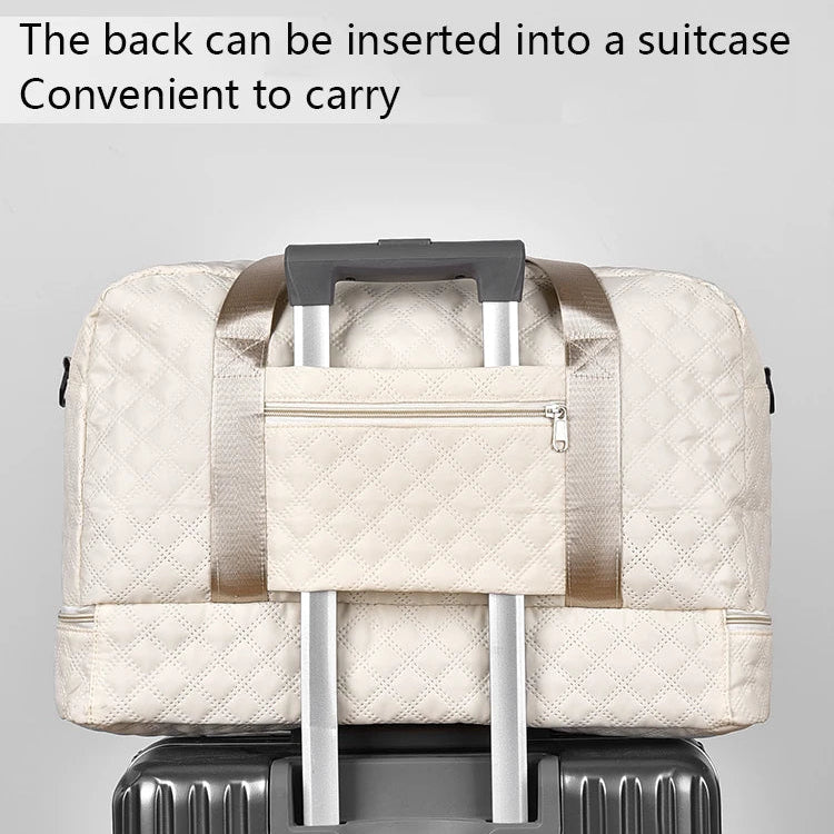 Beige quilted bag with handle attached to a suitcase on a gray background
