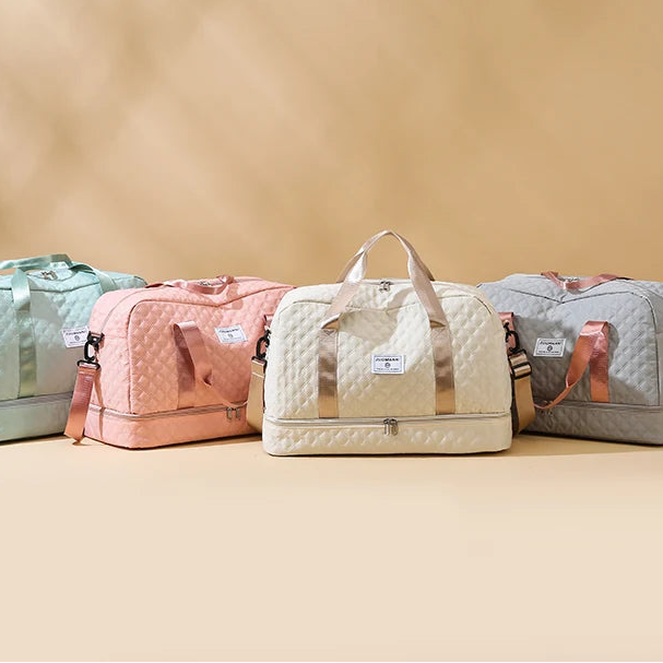 Four quilted duffel bags in different colors on a beige background