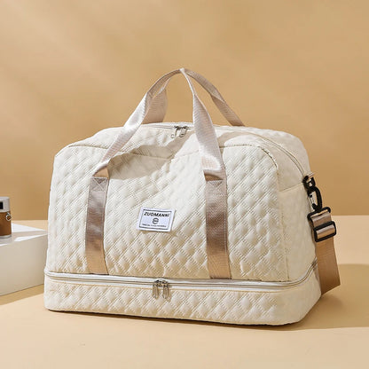 Beige quilted duffel bag with a visible brand label on a beige background