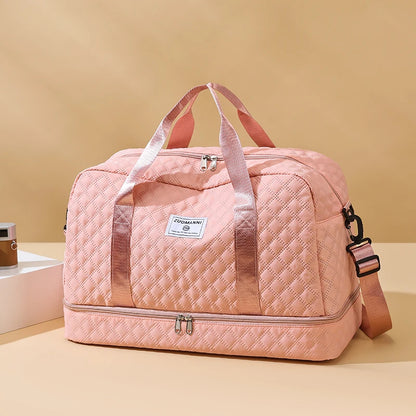 Pink quilted duffel bag with a visible brand logo on a beige background