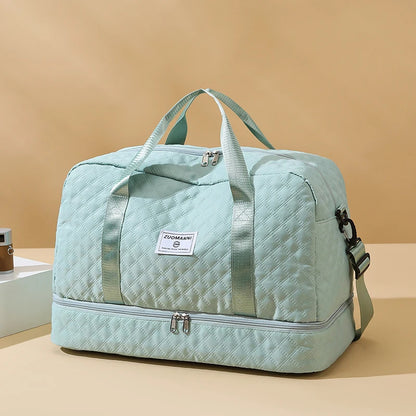 Light blue quilted duffel bag with a visible brand label on a beige background