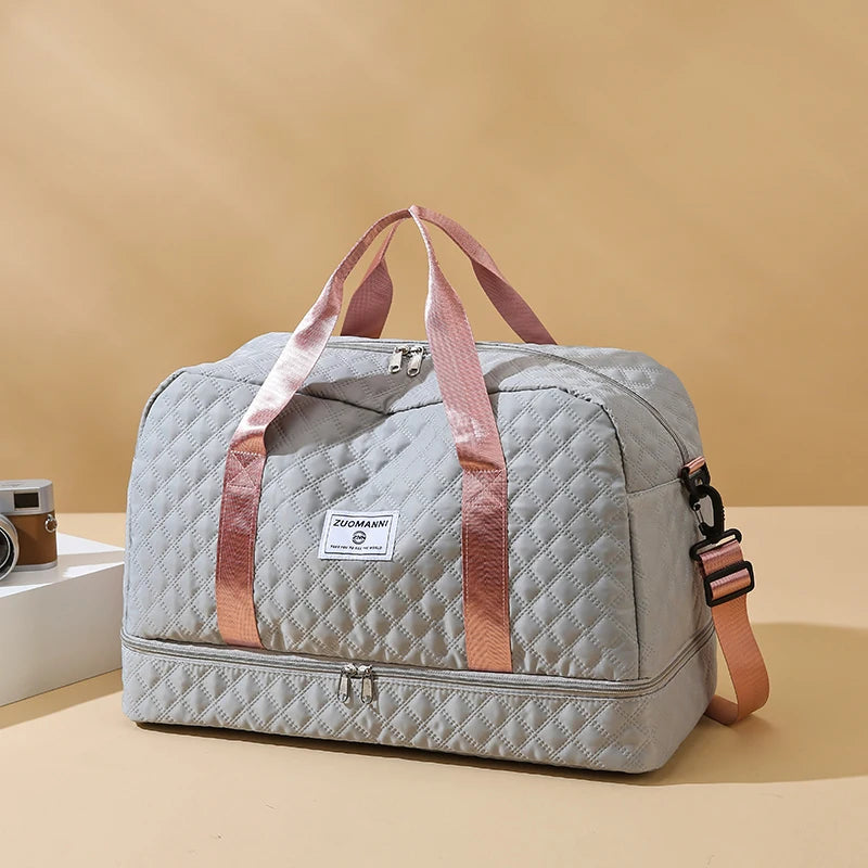 Gray quilted duffel bag with pink straps on a beige background