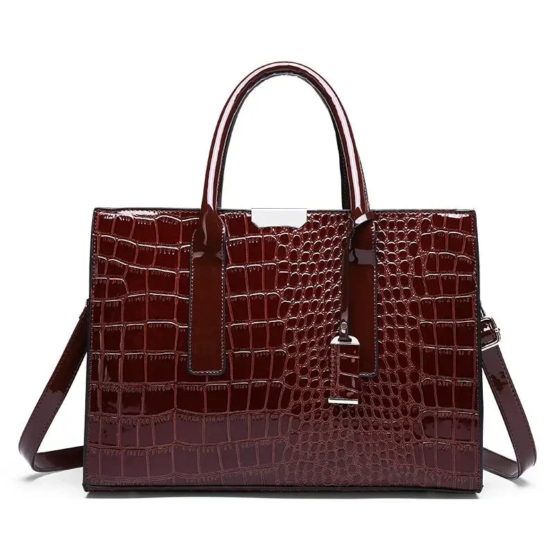 Brown crocodile-patterned handbag with a shoulder strap on a white background