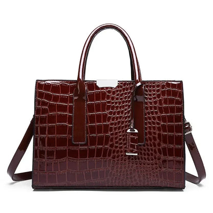 Brown crocodile-patterned handbag with a shoulder strap on a white background
