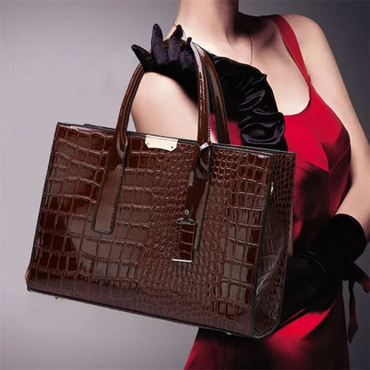 Brown crocodile-patterned handbag held by a person wearing a red dress and black gloves.