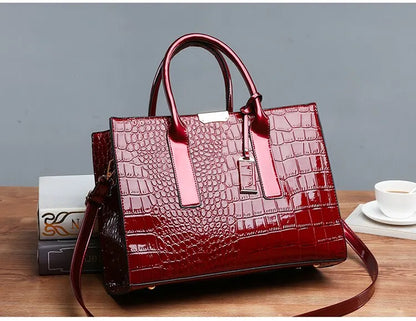 Red handbag with crocodile texture on a wooden surface