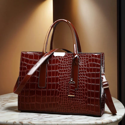 Brown crocodile-patterned handbag on a marble surface with a warm light background