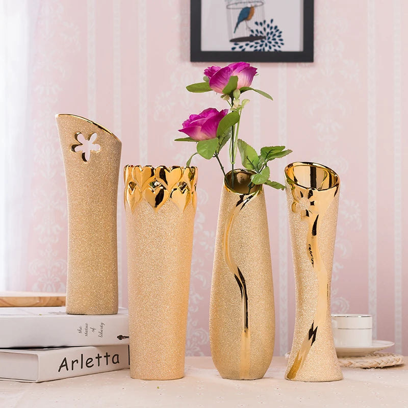 Set of decorative vases with gold accents on a surface with a pink textured wall in the background.