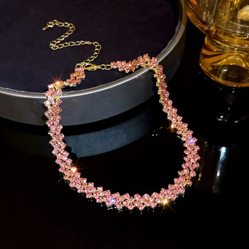 Necklace with pink and gold stones on a dark surface
