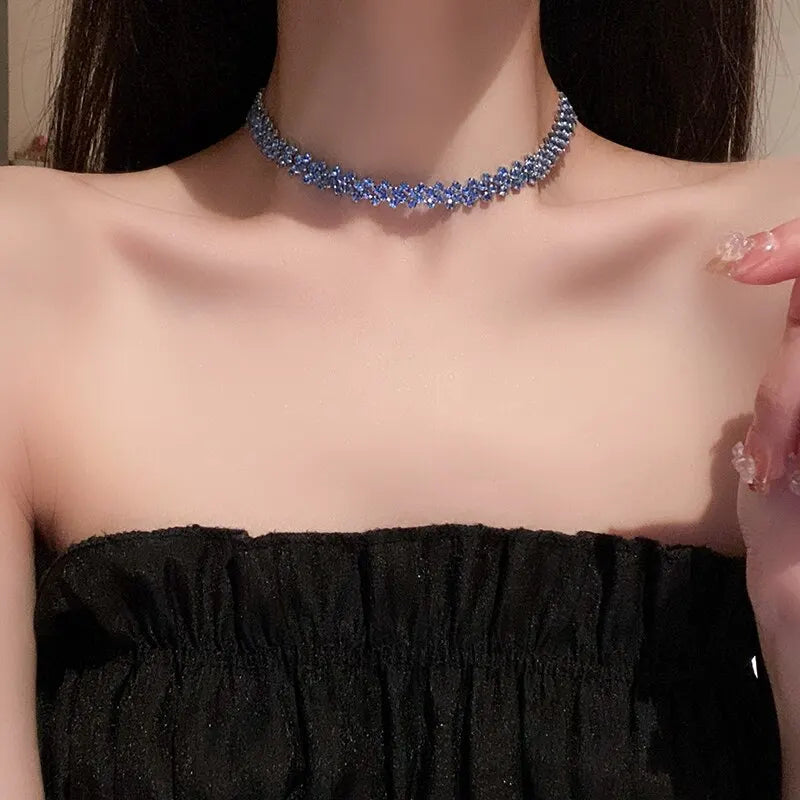 Person wearing a blue beaded necklace with a blurred background