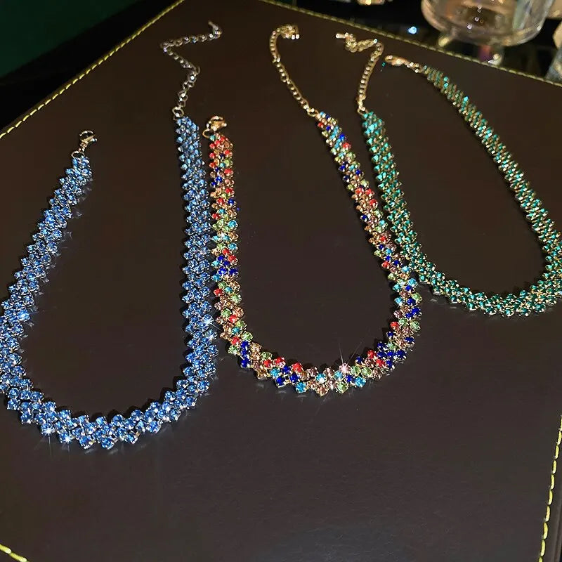 Three colorful beaded necklaces on a dark surface