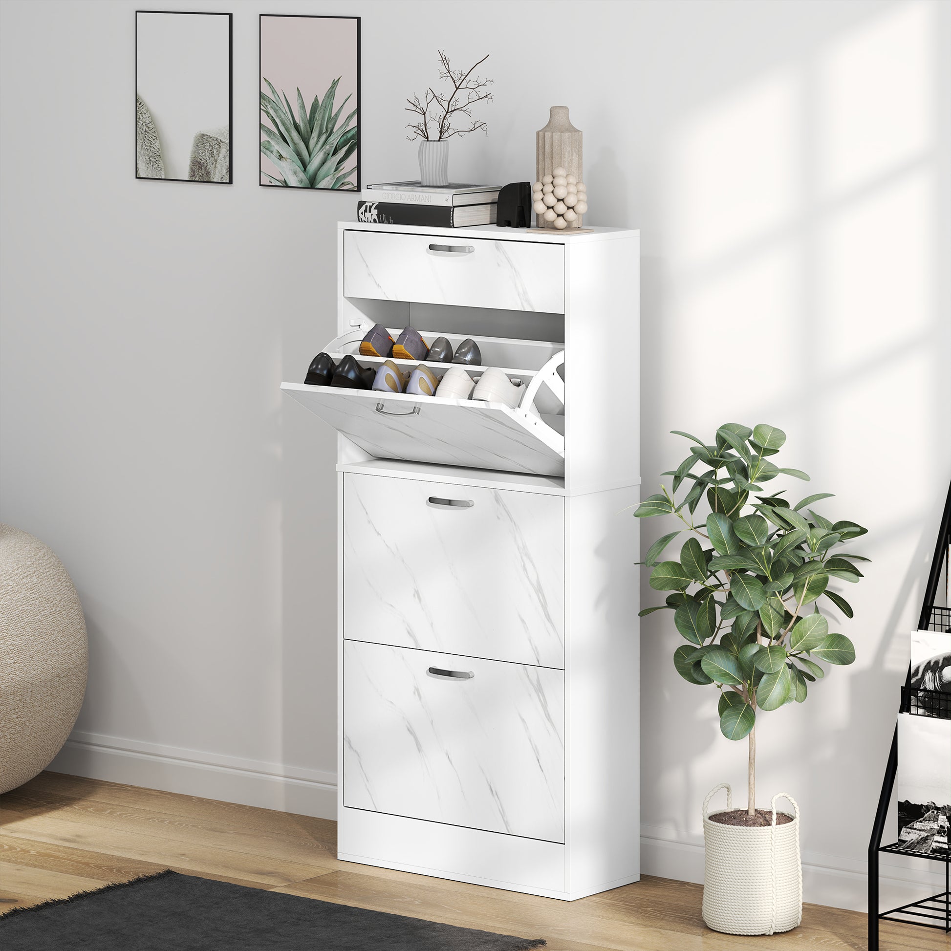 White shoe cabinet with open door showing shoes, next to a potted plant in a room.