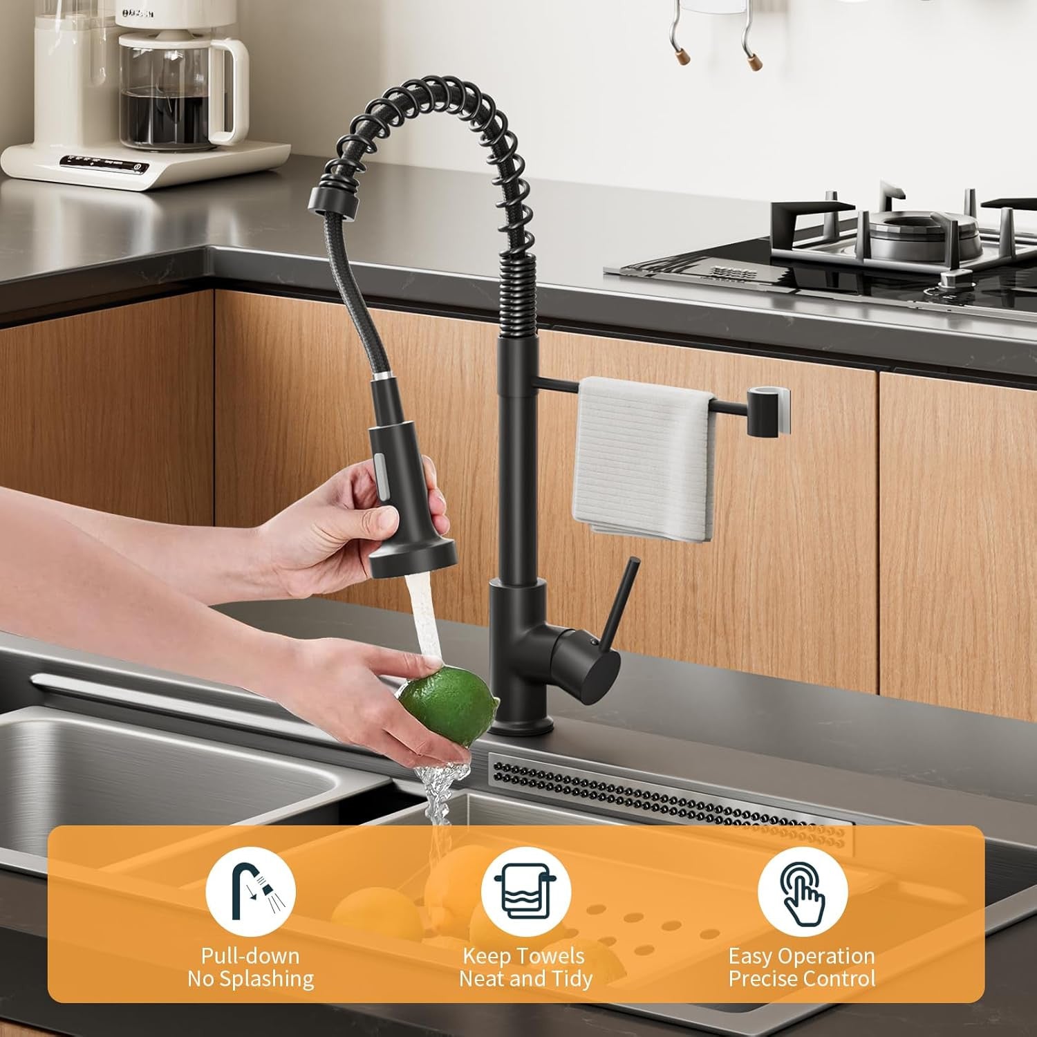 Black pull-down kitchen faucet in a modern kitchen setting with a hand washing a green apple.