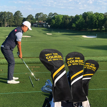 Golfer on a golf course with golf club covers featuring text.