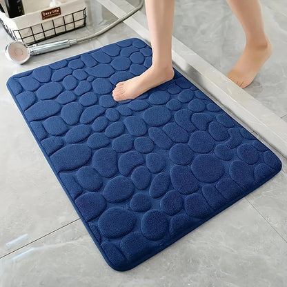 Blue textured bath mat on a bathroom floor with a person stepping onto it.