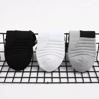 Three pairs of socks in black, white, and gray on a wire rack.