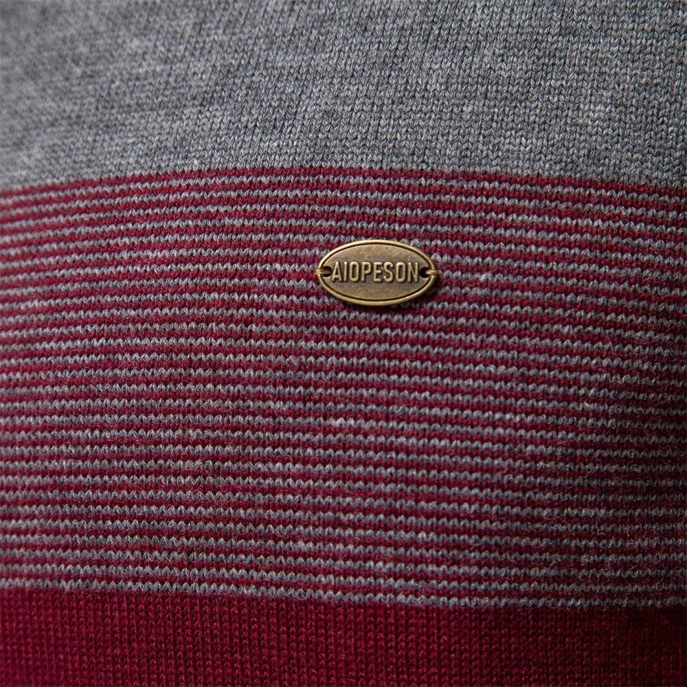 Close-up of a textured fabric with a gold label on a gray and red striped background