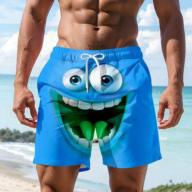 Person wearing blue beach shorts with a cartoonish face design on a beach.