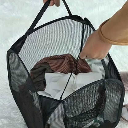 Black mesh laundry bag with clothes being added on a white background